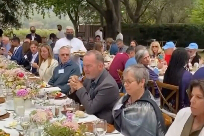 pelosi fundraiser the video shows people sitting close together at long tables.