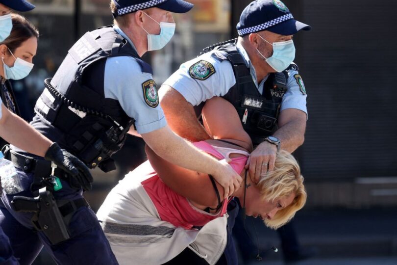 police officers detain a protestor in sydney on august 21, 2021,