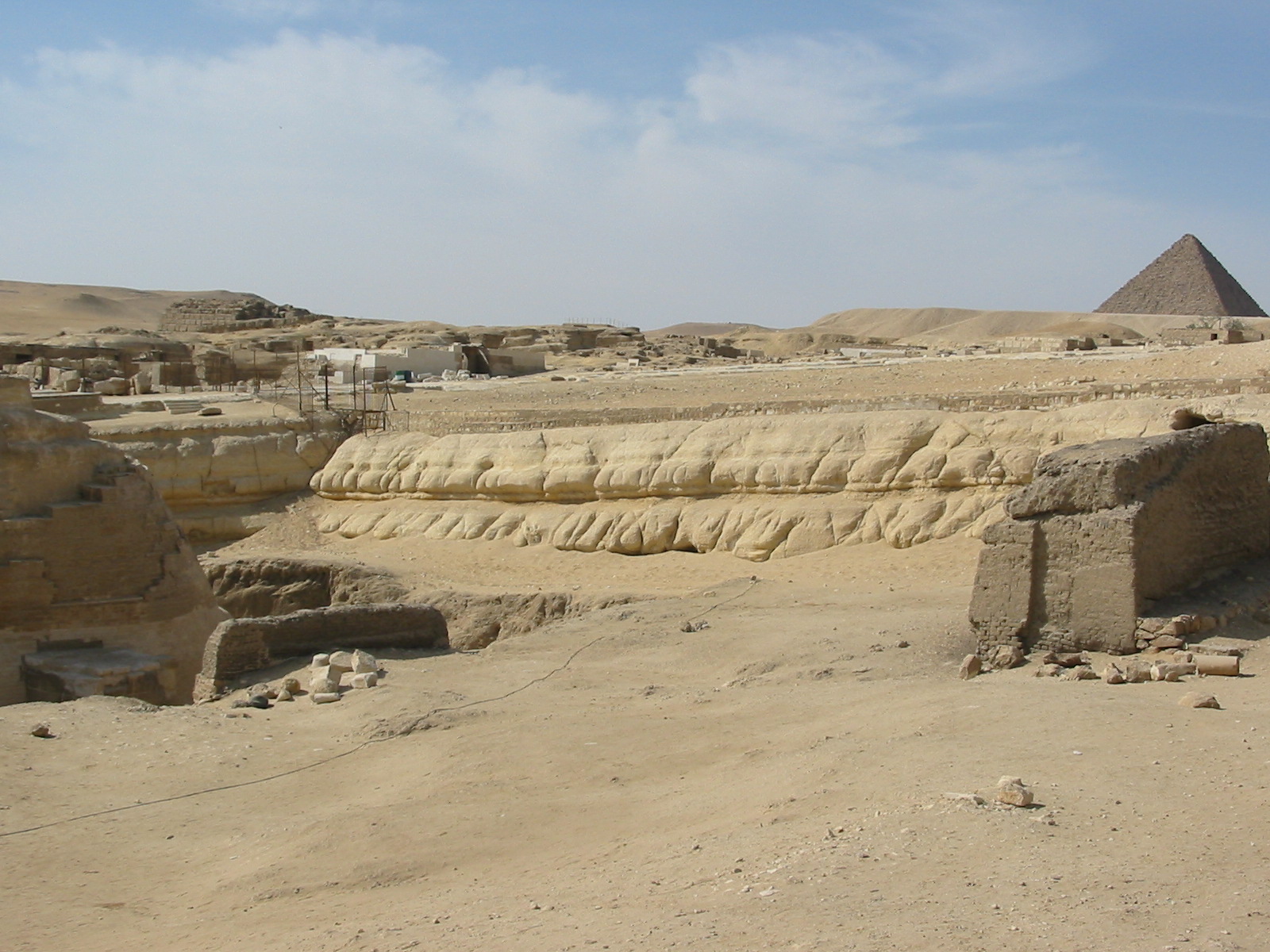 the western wall of the sphinx enclosure, showing erosion consistently along its length